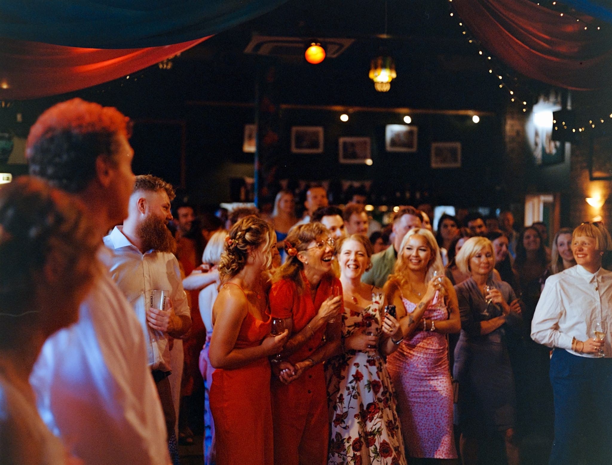Group of people at a festive indoor gathering with colorful decor.